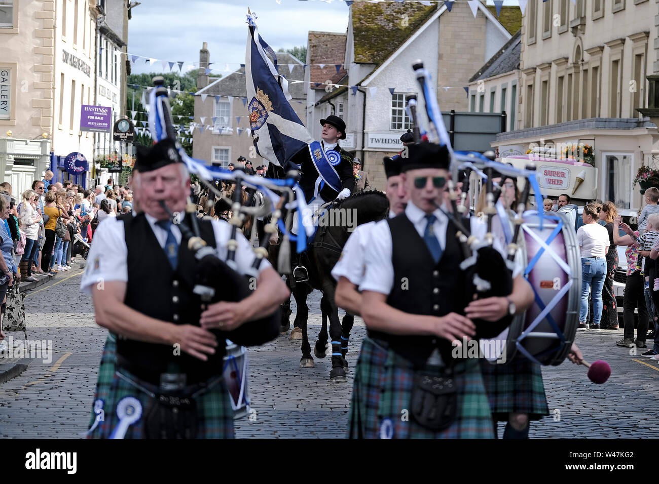 Kelso, SCOTLAND - July 20:    Kelso Civic Week  - Yetholm Ride out, Kelso. Kelso Laddie Mark Henderson carries the Town Flag, returning to the Town after the ride out to Yetholm Saturday 20 July 2019. Ahead of the 200 strong mounted cavalcade with RHM Sean Hook (2018 KL), Craig Logan (2017 KL).   (Credit: Rob Gray ) Credit: Rob Gray/Alamy Live News Stock Photo