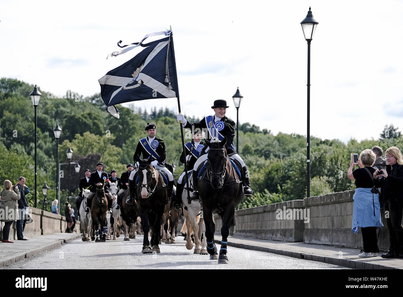 Kelso, SCOTLAND - July 20:    Kelso Civic Week  - Yetholm Ride out, Kelso. Kelso Laddie Mark Henderson carries the Town Flag back across Rennie Bridge, returning to the Town after the ride out to Yetholm Saturday 20 July 2019. Ahead of the 200 strong mounted cavalcade with RHM Sean Hook (2018 KL), Craig Logan (2017 KL).   (Credit: Rob Gray ) Stock Photo