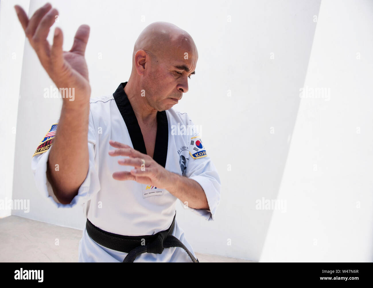 Black belt Sensei martial arts instructor demonstrating Taekwondo form. Stock Photo