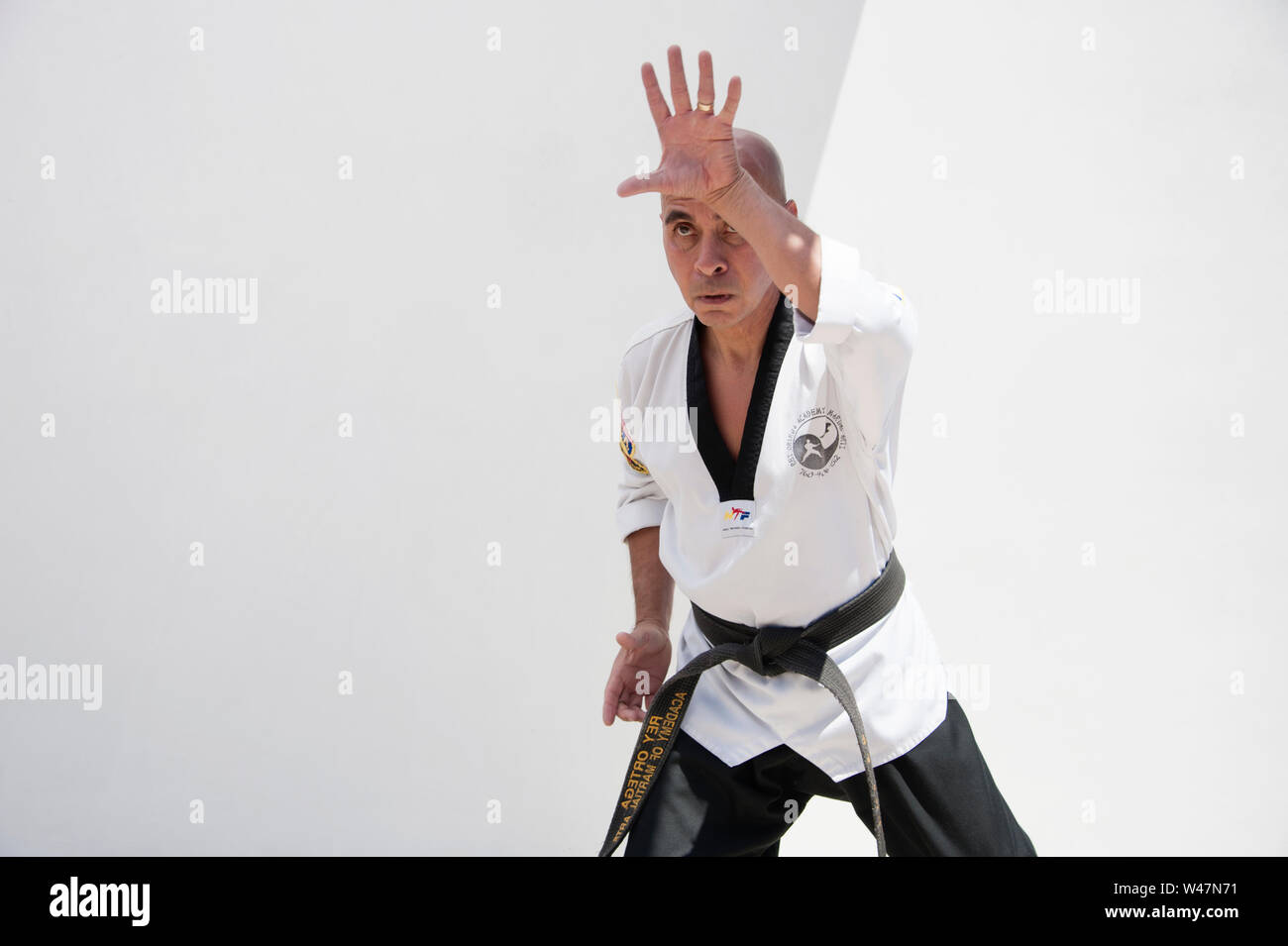 Black belt Sensei martial arts instructor demonstrating Taekwondo form. Stock Photo