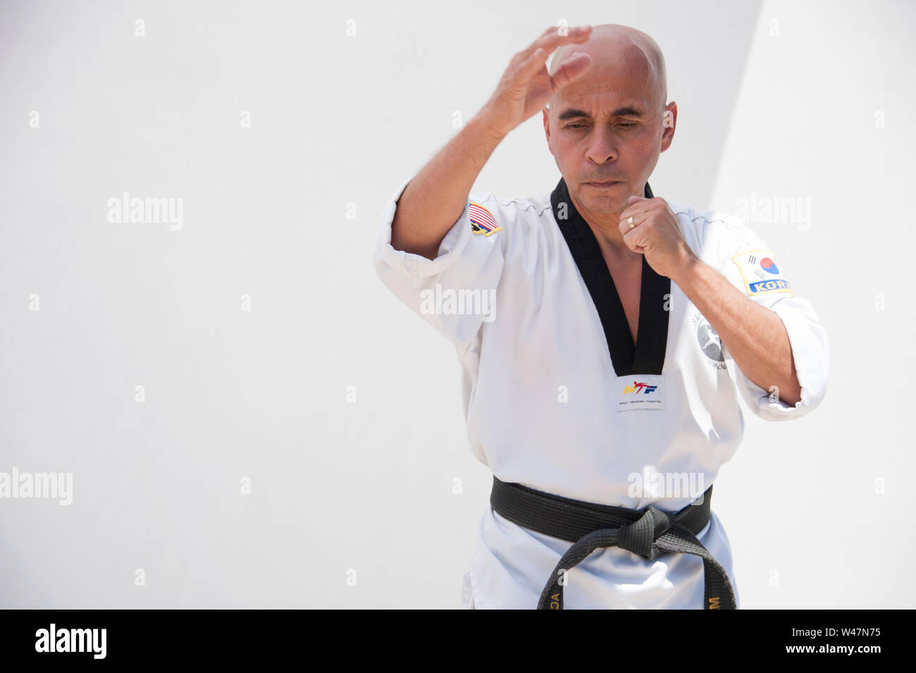 Black belt Sensei martial arts instructor demonstrating Taekwondo form. Stock Photo