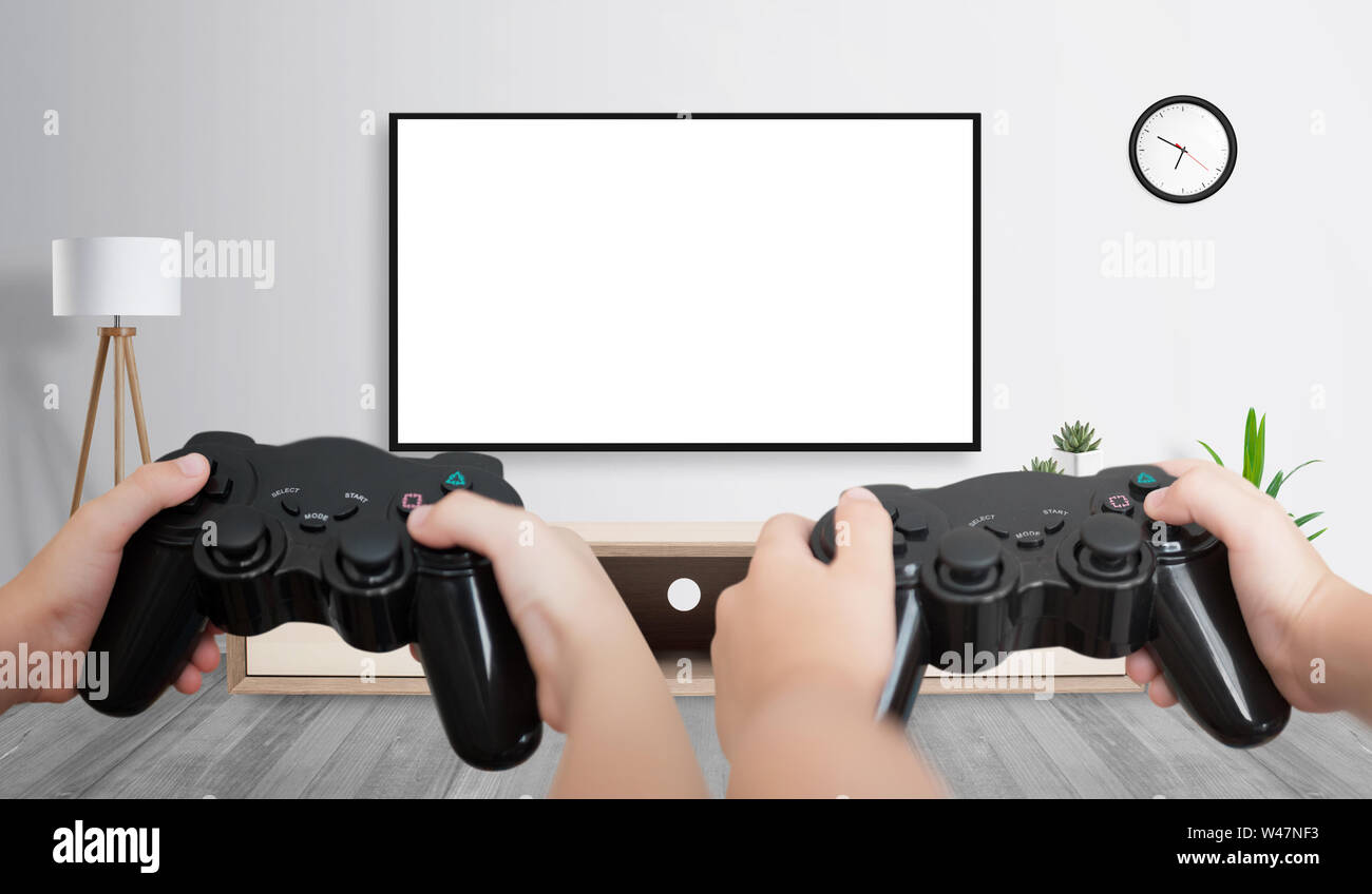 Two friends playing game on large TV with isolated screen for game presentation. Stock Photo