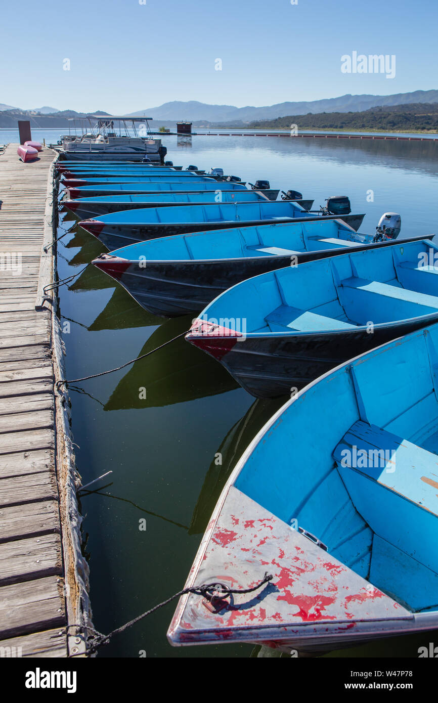Blue Fishing boats tied up to a wood jetty for rent on Lake Cachuma