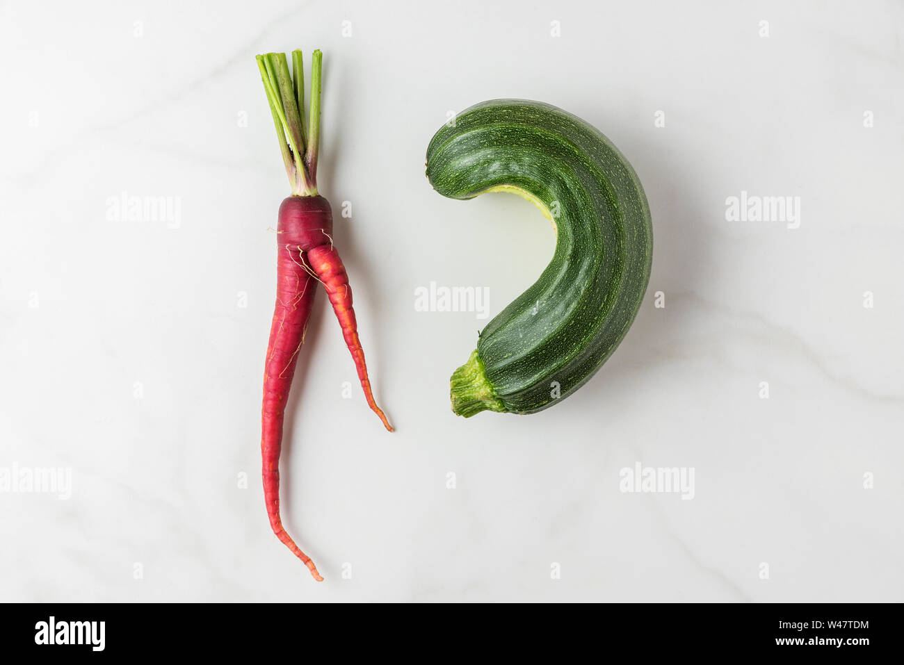 Trendy ugly organic vegetables carrot and zucchini from home garden on white marble table. top view. flat lay Stock Photo