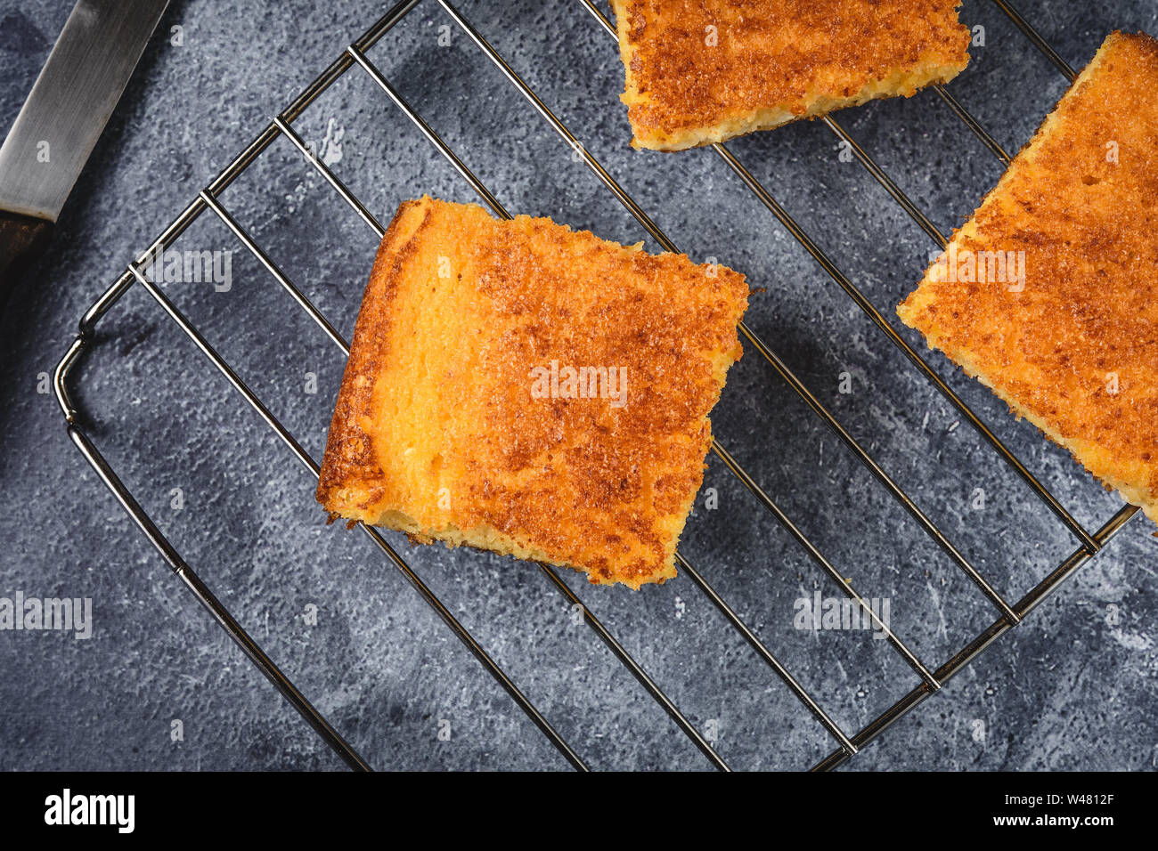Yellow Corn Bread Squares Slices on Dark Rustic Background Stock Photo