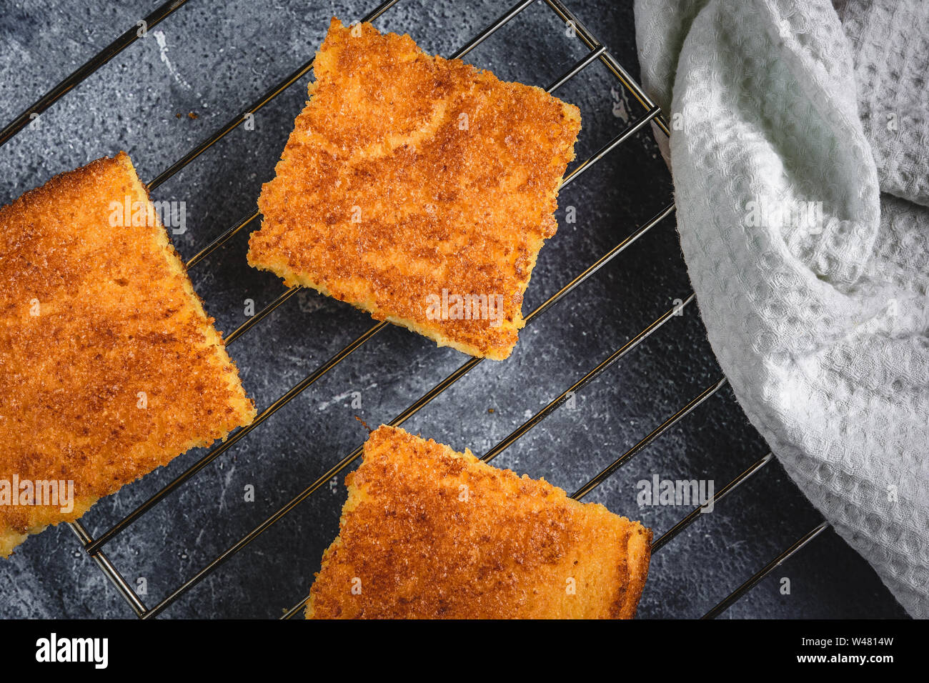 Yellow Corn Bread Squares Slices on Dark Rustic Background Stock Photo