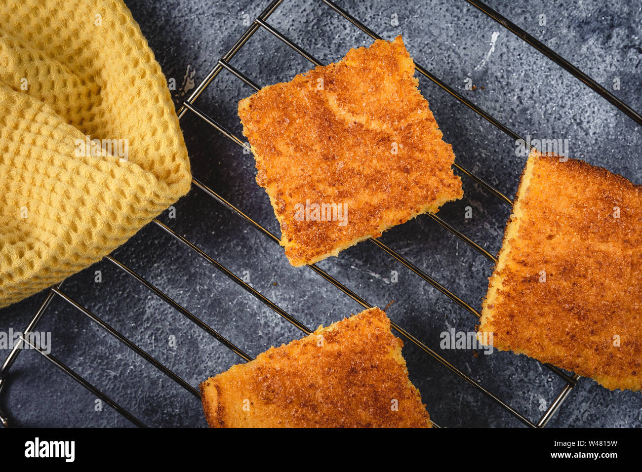 Yellow Corn Bread Squares Slices on Dark Rustic Background Stock Photo