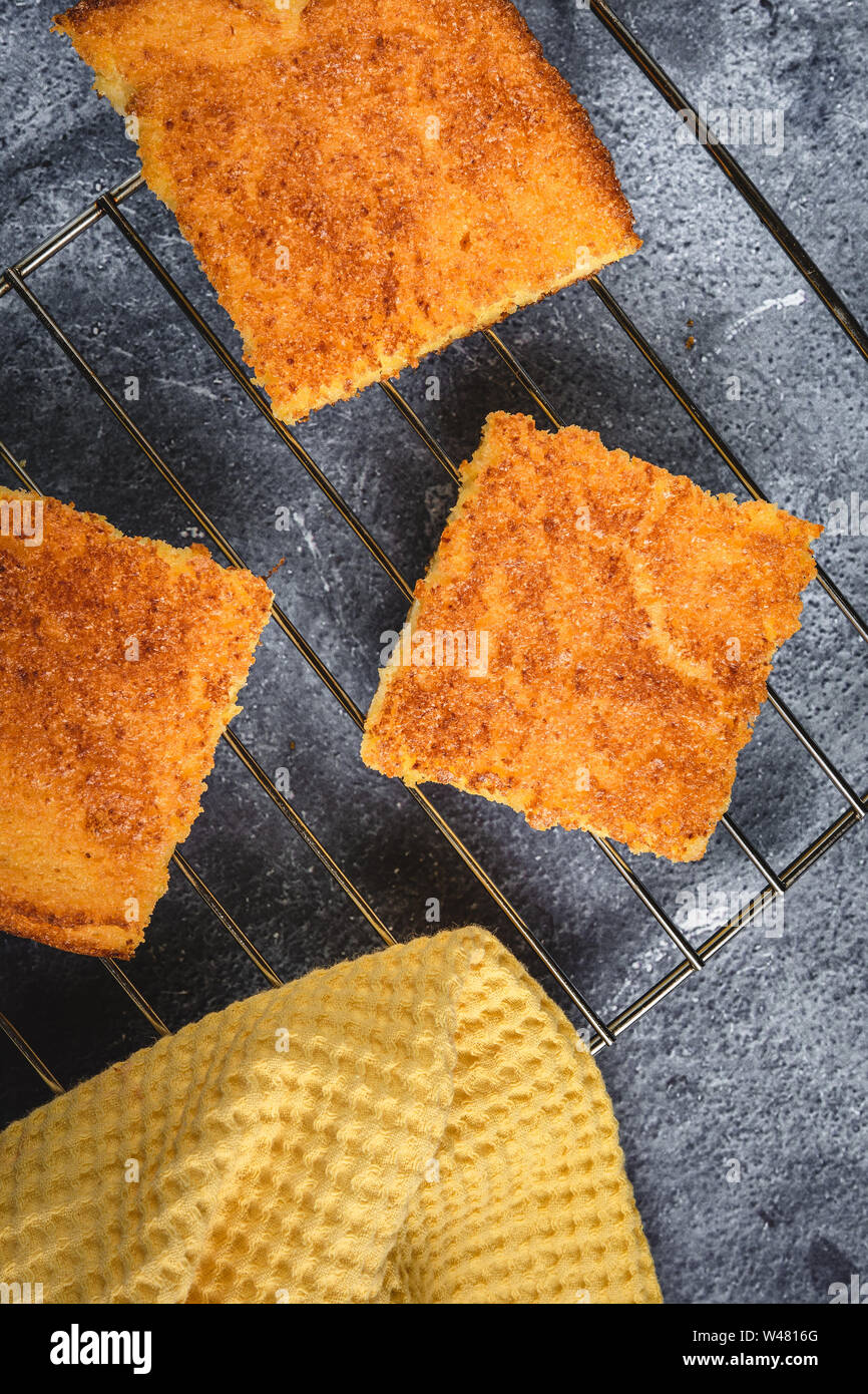 Yellow Corn Bread Squares Slices on Dark Rustic Background Stock Photo