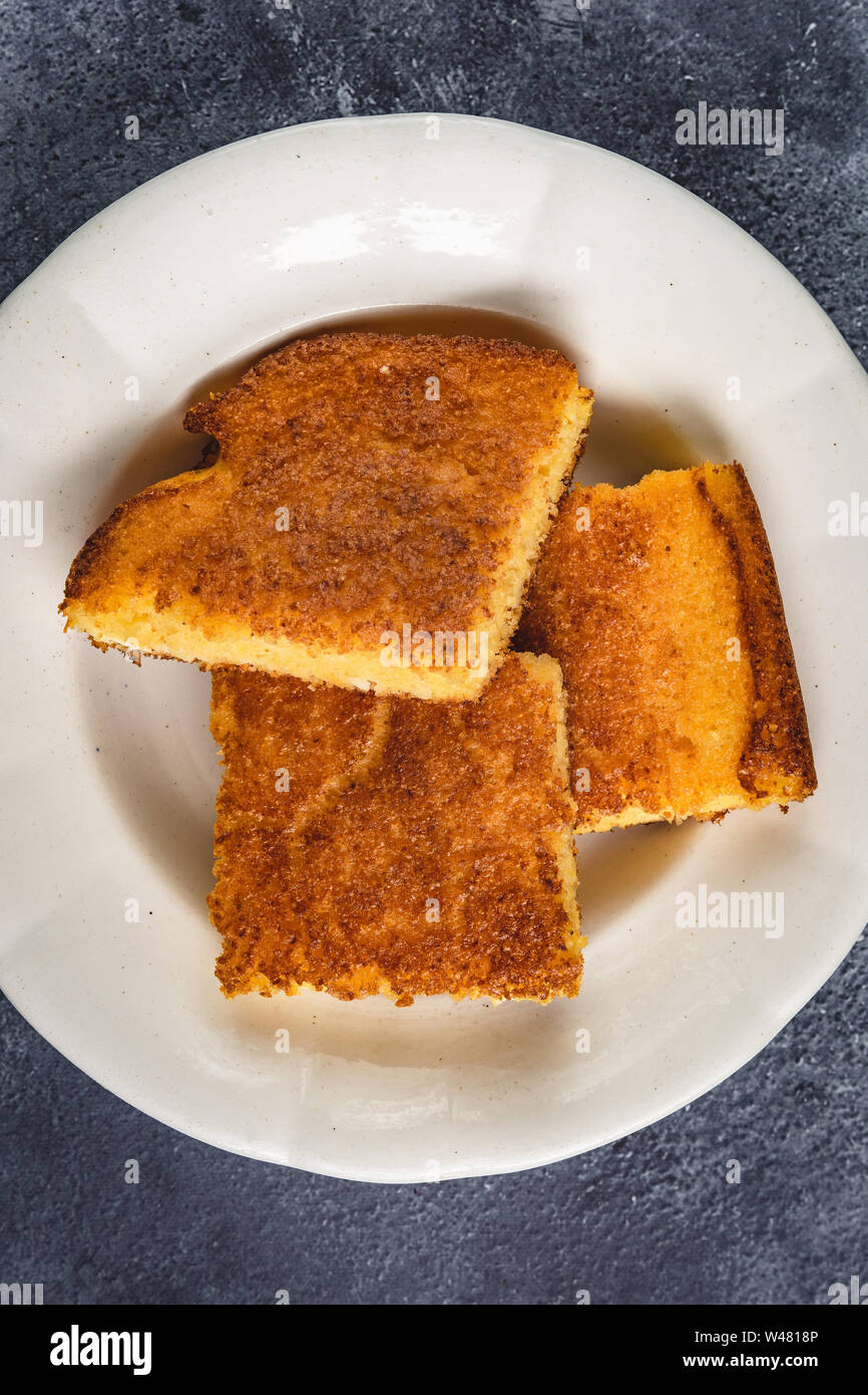 Yellow Corn Bread Squares Slices on Dark Rustic Background Stock Photo
