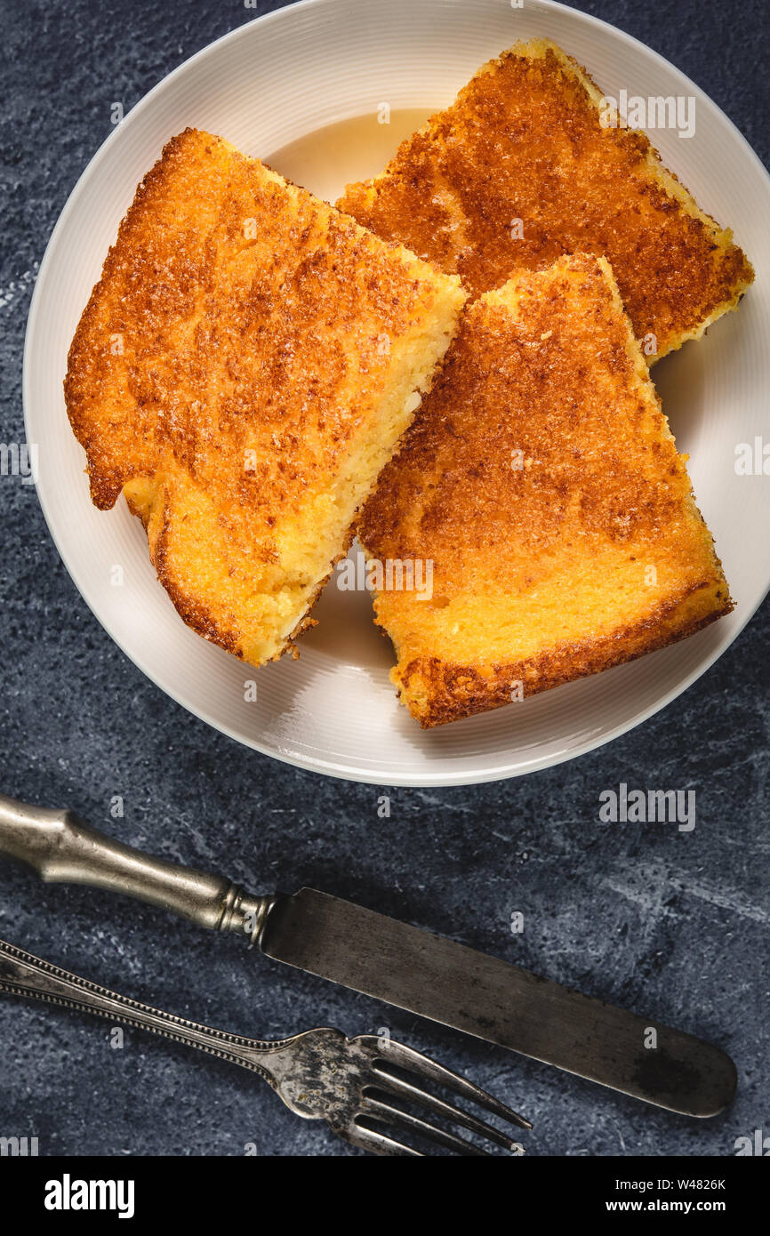 Corn Bread Squares Slices in White Plate on Dark Blue Rustic Background Stock Photo