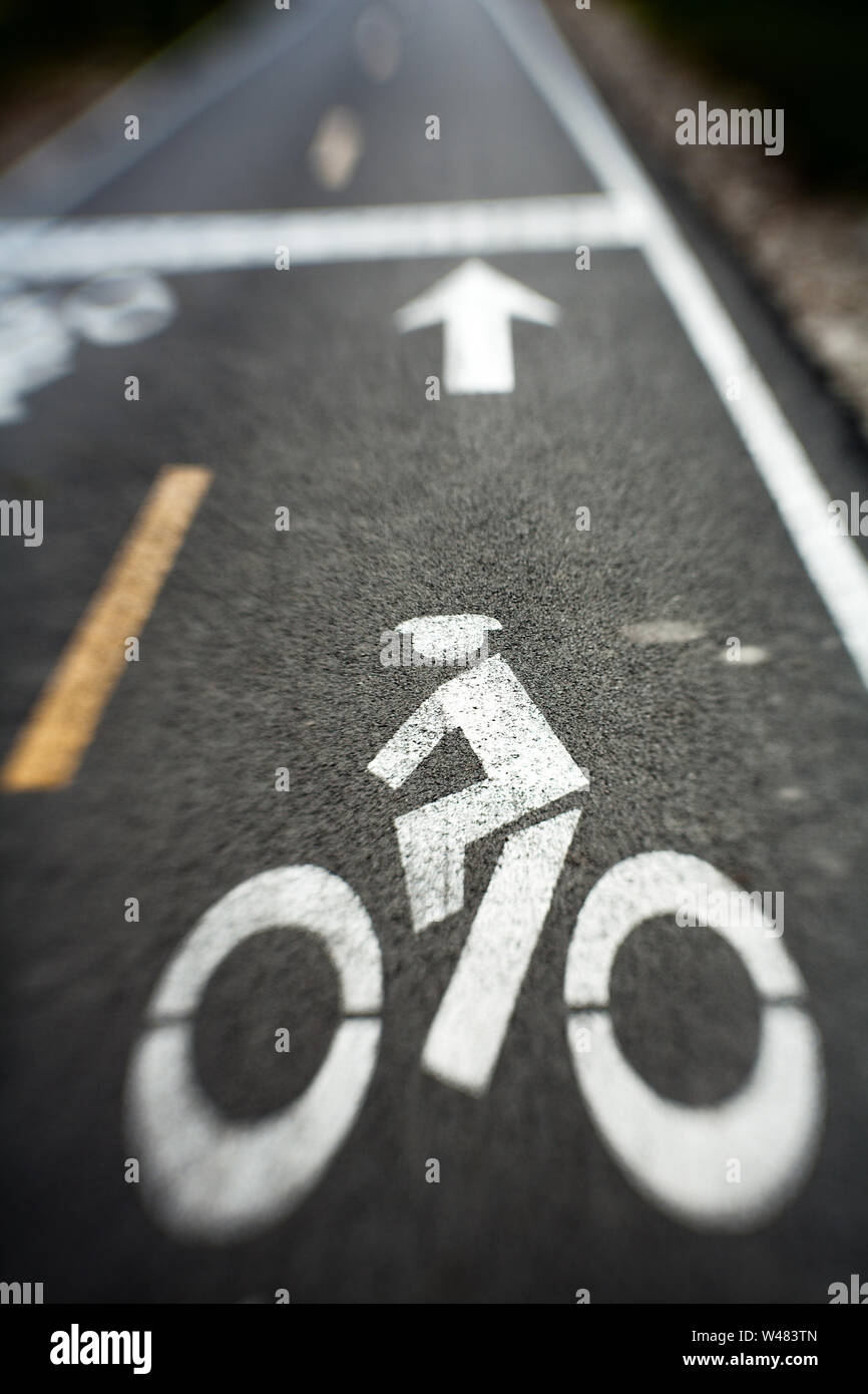 Lensbaby photo of city street with bike lane symbol painted in white Stock Photo