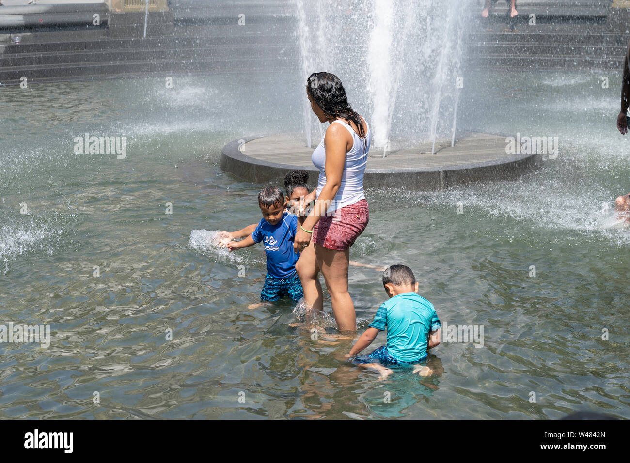 New York, NY - July 20, 2019: New Yorkers cool down in Washington Square fountain as extreme heat wave hit city and temperature reached 105 degrees Fahrenheit (40 degrees Celsius) Stock Photo