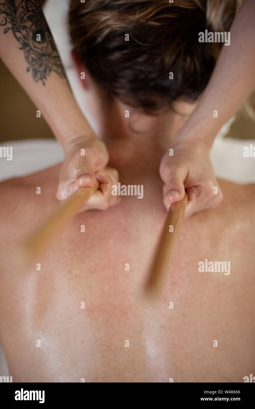 Hot Bamboo massage referred to as bamboo fusion massage, is a type of massage therapy. The smooth sticks are more penetrating for deep tissue. Stock Photo