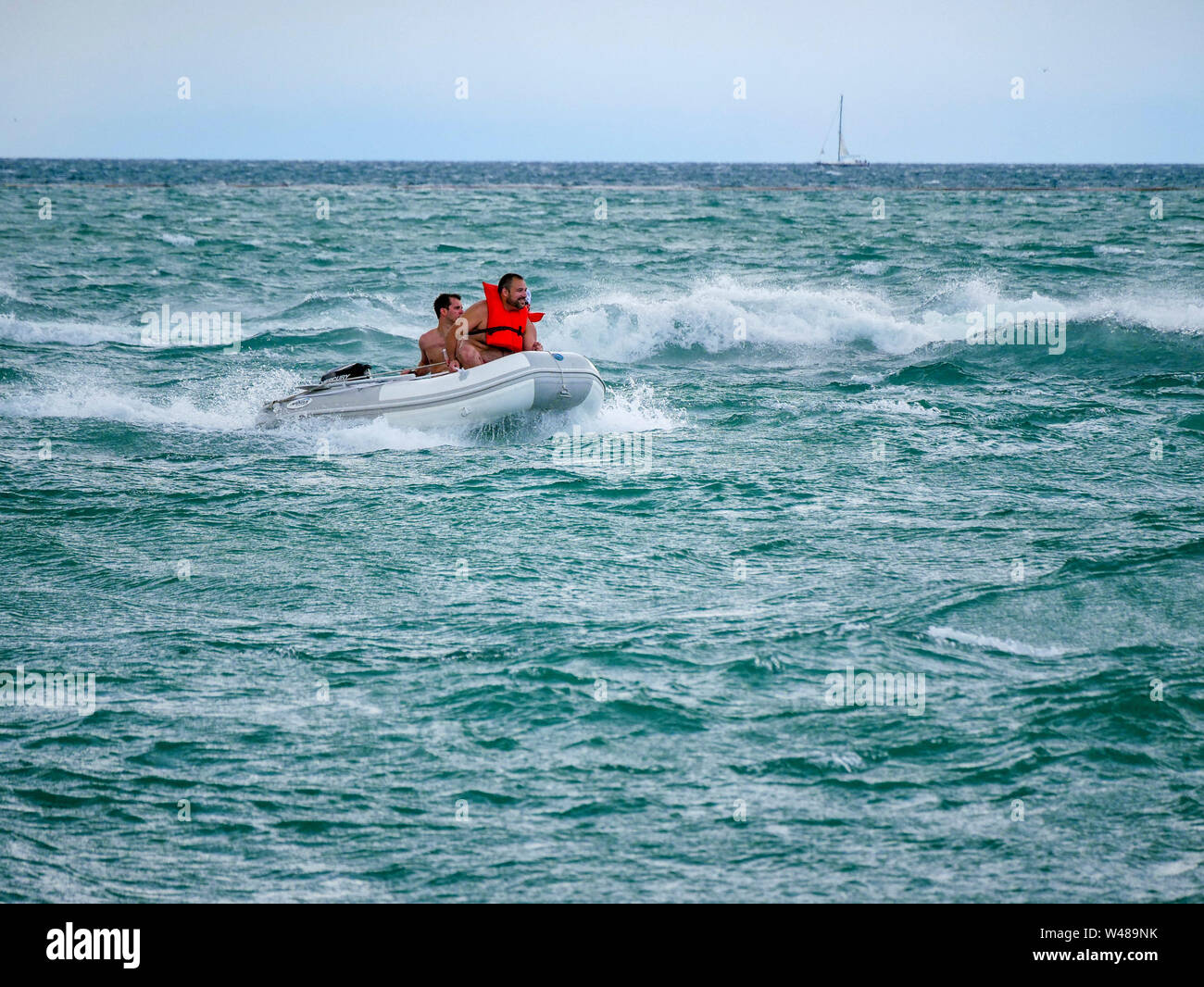 Men in a motorized inflatable dinghy, choppy water, Lake Michigan, Chicago, Illinois. Stock Photo
