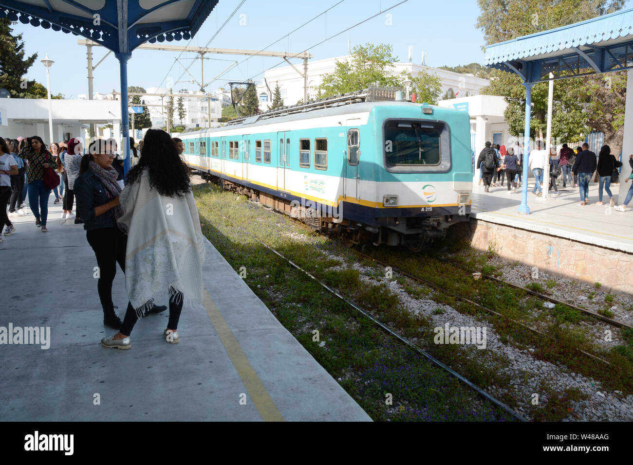Tunisian commuters at the Sidi Bou Said metro stop in Tunis await the arrival of a subway train, in Tunisia. Stock Photo