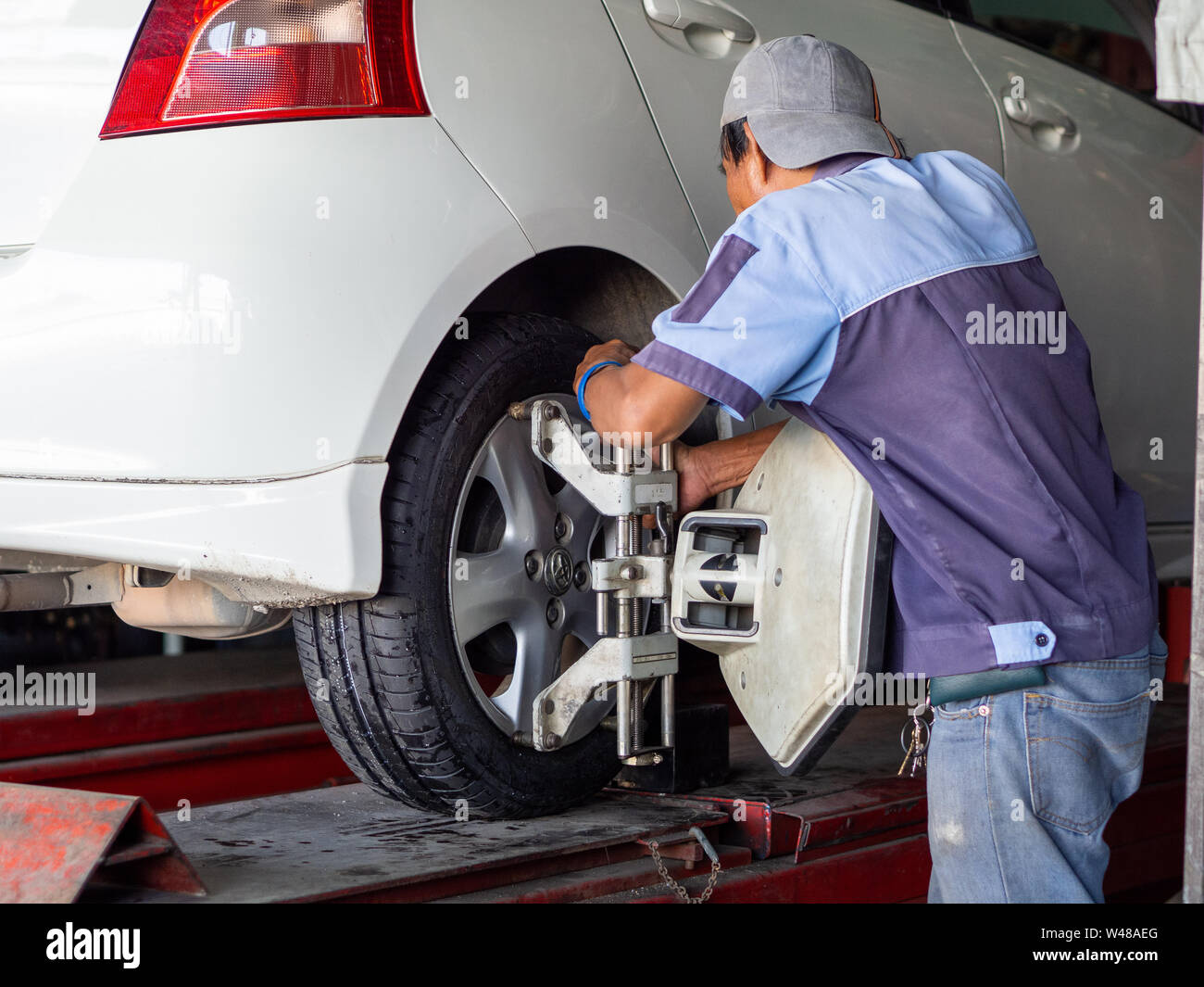 Mechanician changing car wheel in auto repair shop Stock Photo - Alamy
