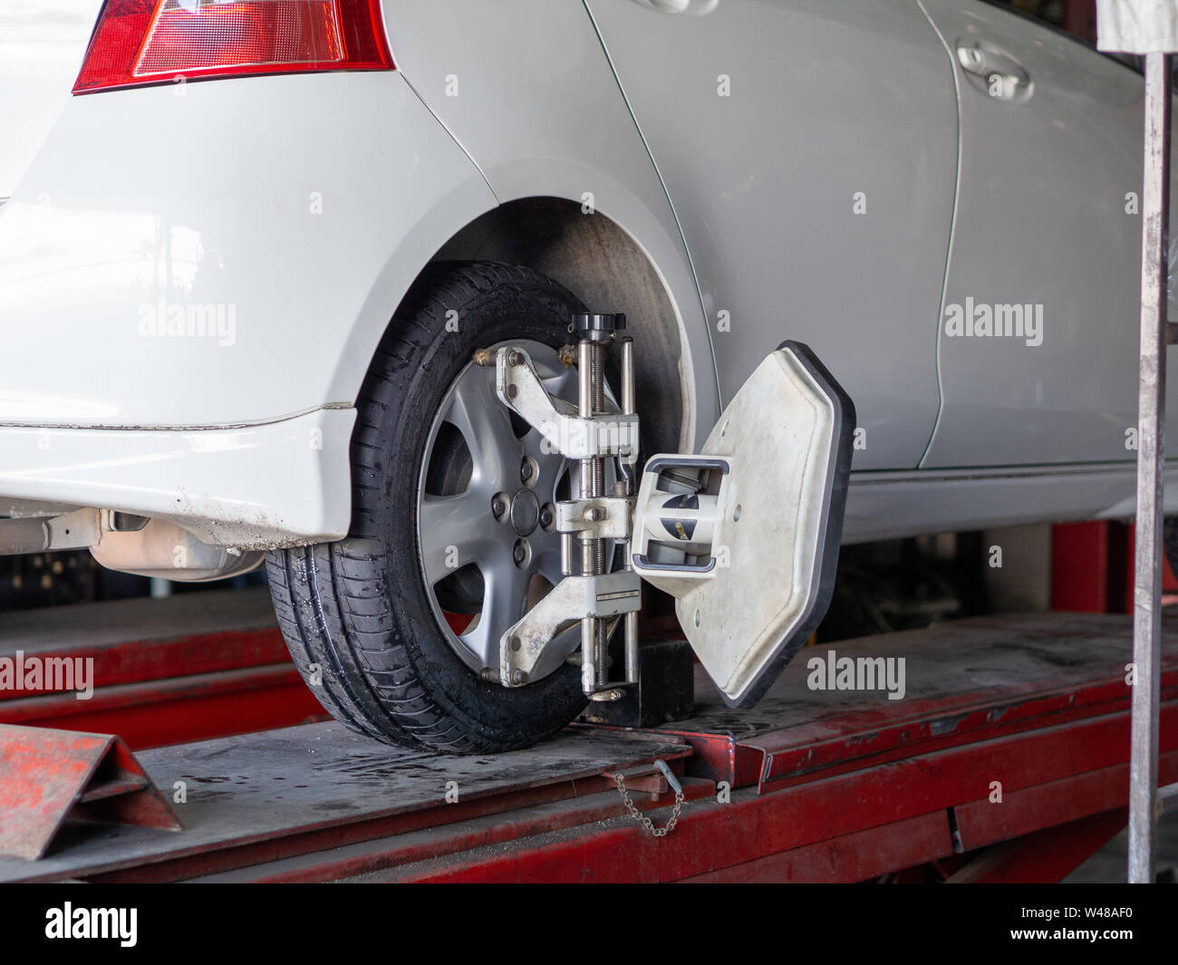 Mechanician changing car wheel in auto repair shop Stock Photo - Alamy
