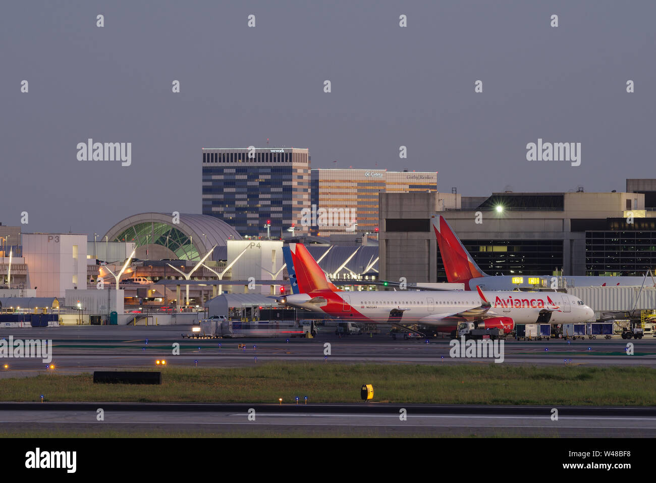 Image, looking south, showing an Avianca Airbus aircraft at a gate in the Los Angeles International Airport, LAX, at dusk. Stock Photo