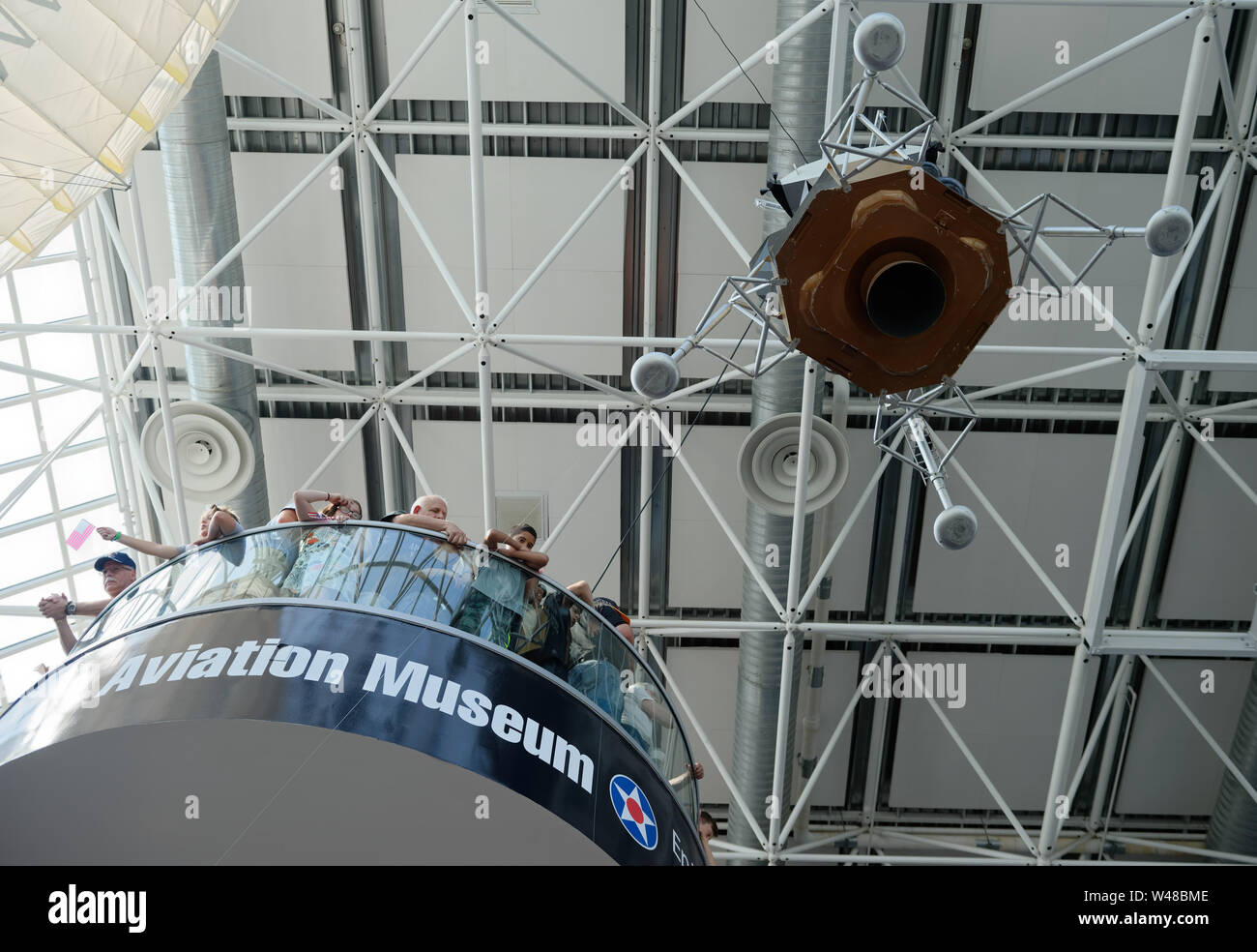 Garden City, New York, USA. 20th July, 2019. Visitors look down from high landing on the 3rd floor staircase near the 1/3 scale model of Apollo 11 Lunar Module The Eagle suspended from ceiling and ready to descend at the exact time the Apollo 11 Lunar Module, The Eagle, landed on the Moon 50 years ago, at the Apollo at 50 Countdown Celebration at Cradle of Aviation Museum in Long Island. Credit: Ann Parry/ZUMA Wire/Alamy Live News Stock Photo
