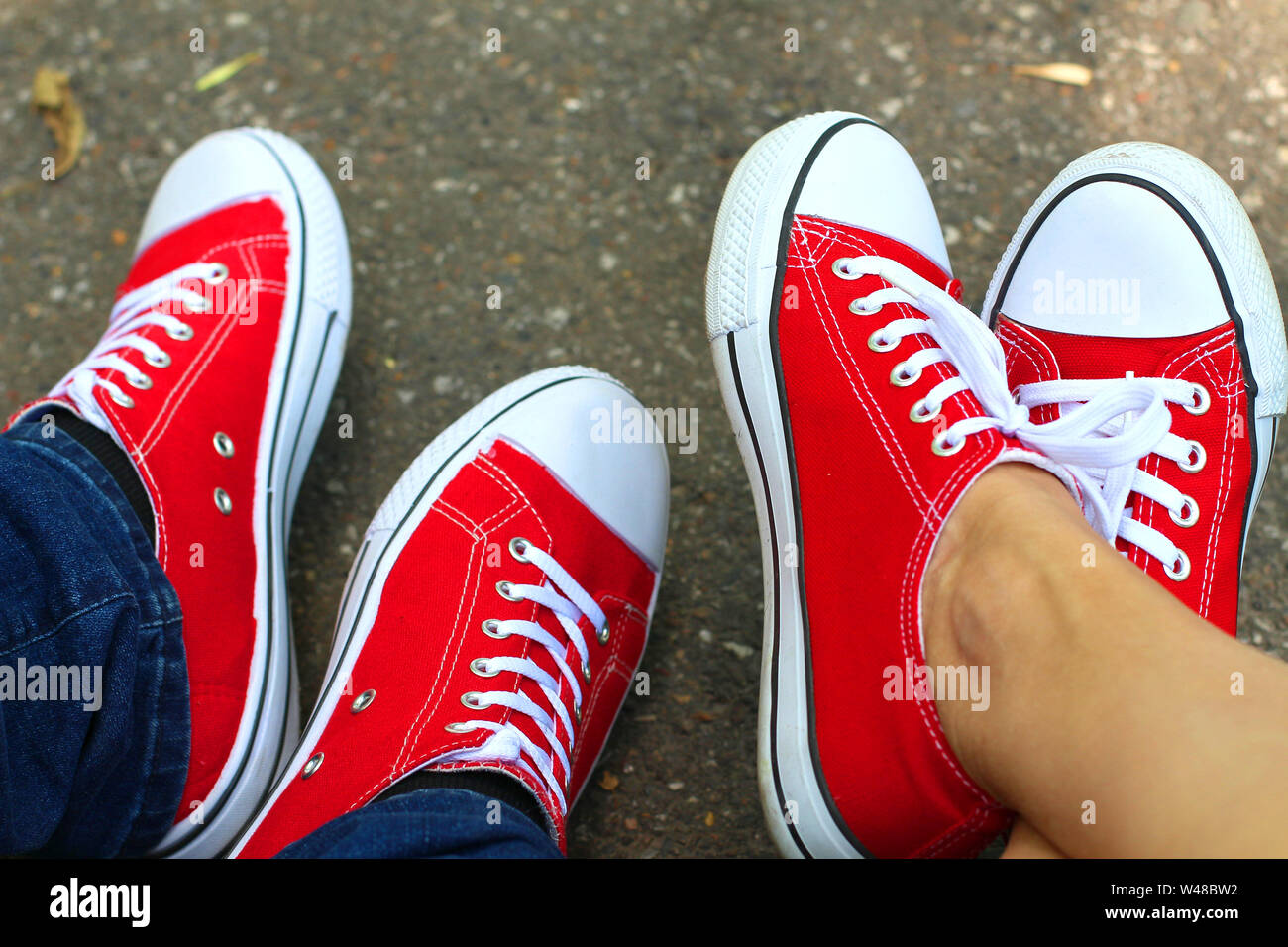 Red sneakers shoes on woman's and man's feet. Sneakers shoes Couple. Copy  space Stock Photo - Alamy