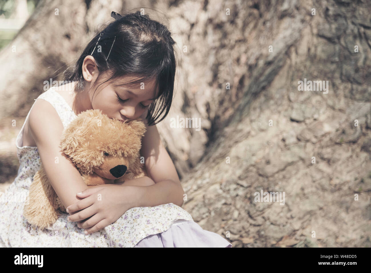 https://c8.alamy.com/comp/W48DD5/sad-girl-feeling-alone-in-the-park-lonely-concepts-beautiful-toddler-girl-and-fluffy-stay-alone-under-the-big-tree-W48DD5.jpg