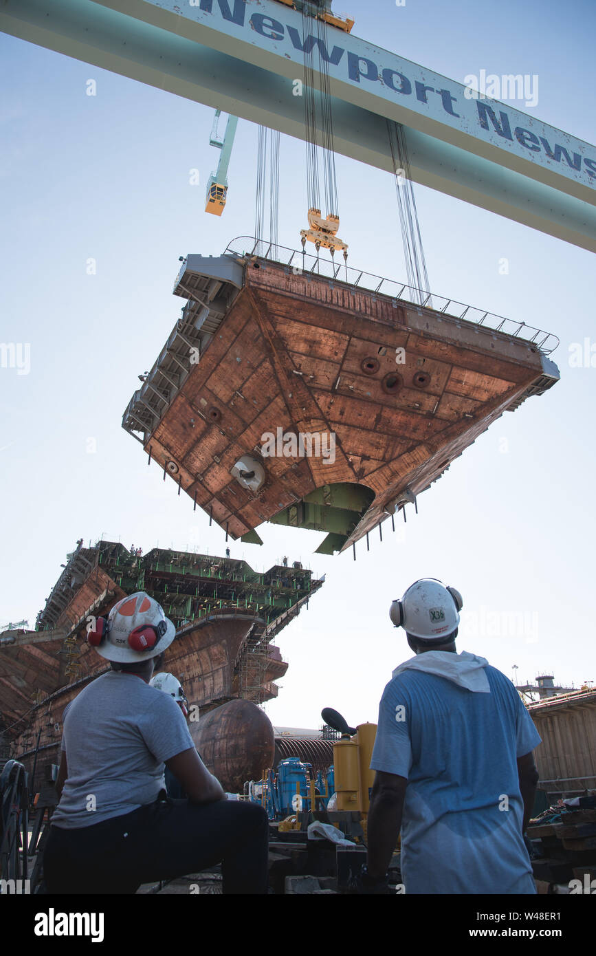 190710-N-N2201-058 NEWPORT NEWS, Va. (July 10, 2019) Shipyard workers watch as the upper bow unit of the future aircraft carrier USS John F. Kennedy (CVN 79) is fitted to the primary structure of the ship, July 10, 2019, at Huntington Ingalls Industries Newport News Shipbuilding. John F. Kennedy is the second Gerald R. Ford-class aircraft carrier and the second aircraft carrier to be named after the 35th president. The 1,096-foot hull is longer than three football fields and more than 3,000 shipbuilders and 2,000 suppliers from across the country are supporting construction of the ship. The ch Stock Photo