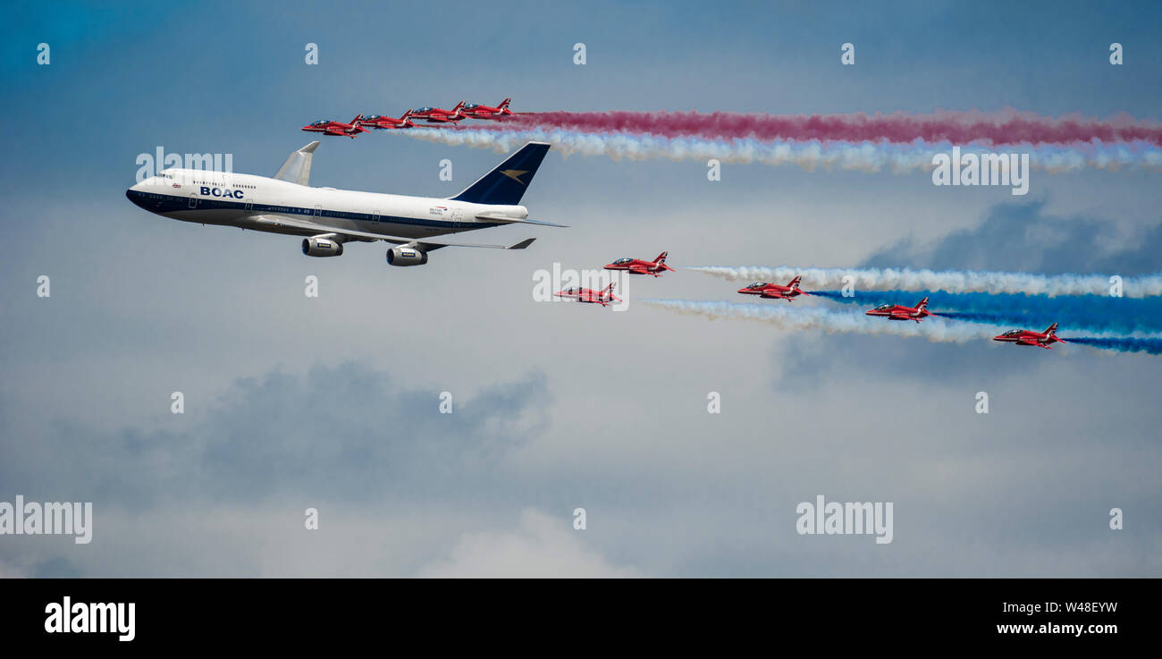 The British Air Force’s Red Arrows and a British Airways’ Boeing 747-436 conduct a flypast during the 2019 Royal International Air Tattoo at RAF Fairford, England, July 20, 2019. This year, RIAT commemorated the 70th anniversary of NATO and highlighted the United States' enduring commitment to its European allies. (U.S. Air Force photo by Tech Sgt. Aaron Thomasson) Stock Photo