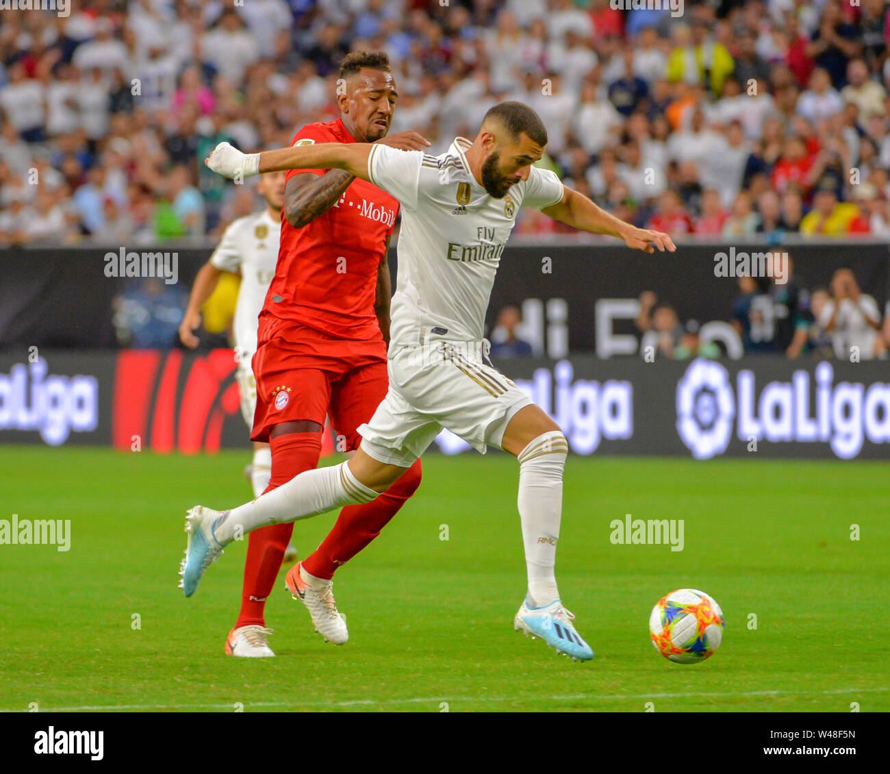 Houston, TX, USA. 20th July, 2019. Real Madrid forward, Karim Benzema (9), moves the ball downfield as Bayern defender, Jerome Boateng (17), tries to steal it away, during the 2019 International Champions Cup match between Real Madrid and FC Bayern, at NRG Stadium in Houston, TX. FC Bayern defeated Real Madrid, 3-1. Mandatory Credit: Kevin Langley/Sports South Media/CSM/Alamy Live News Stock Photo