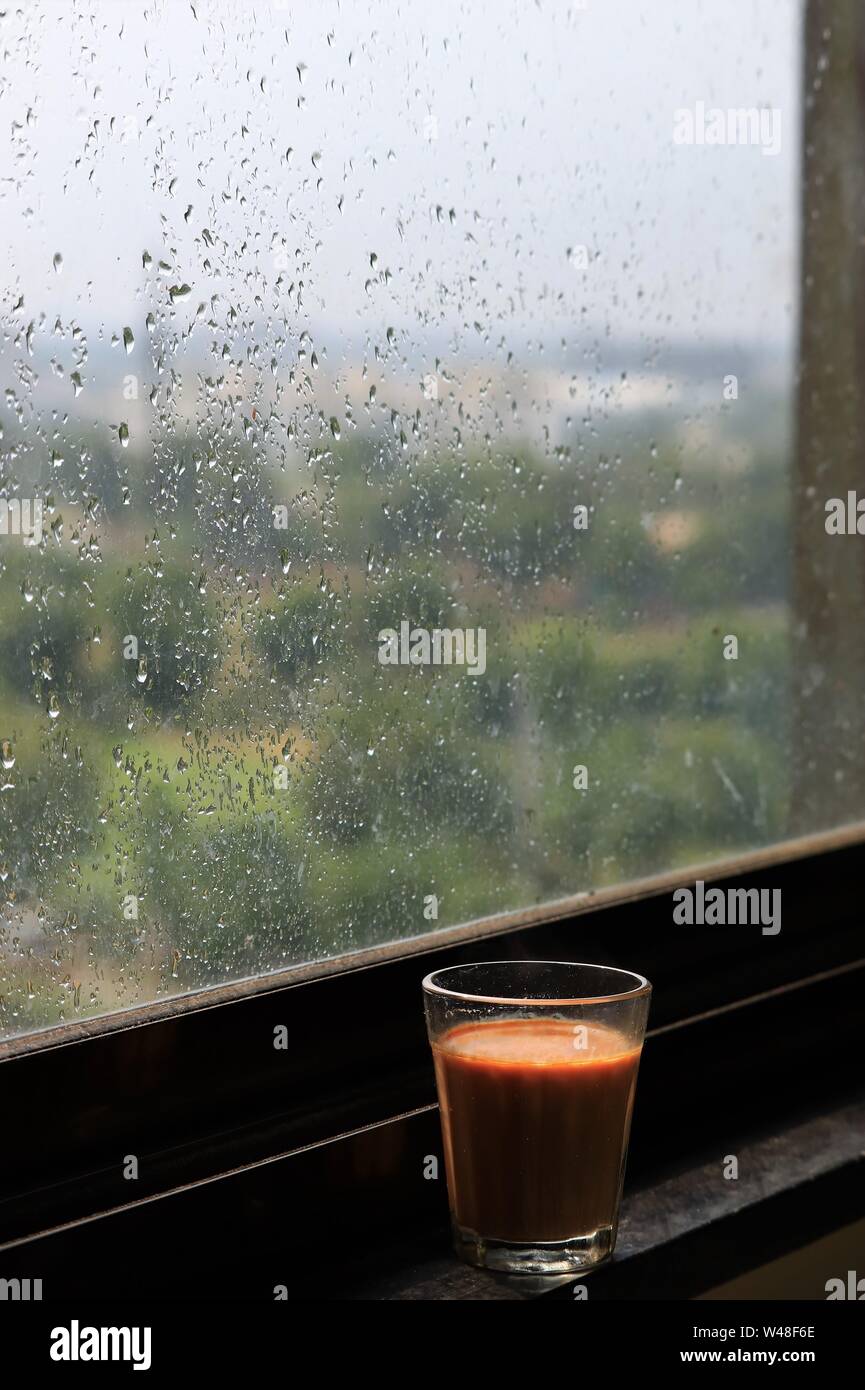 Cutting chai/a glass of chai/tea near the window sill during monsoon