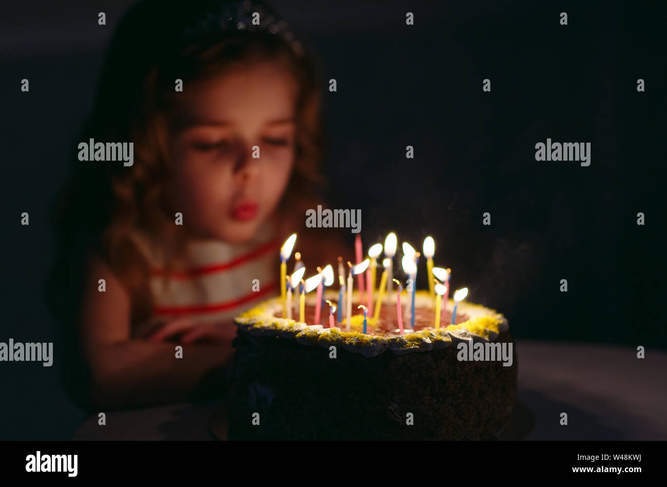 Birthday. A little sweet girl blows out candles on the stoke Stock