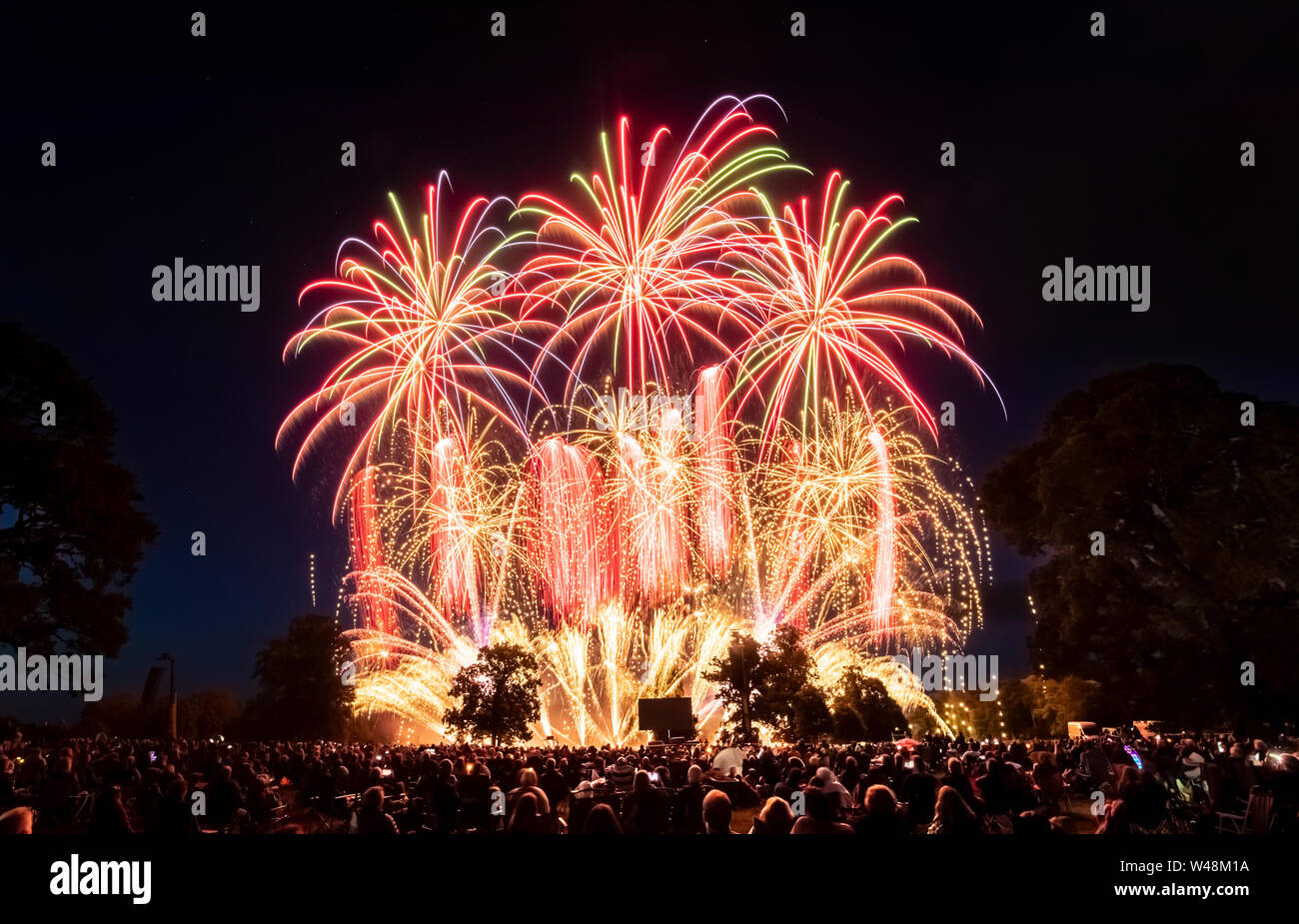 Thousands of people watch a fireworks display, as the UK's finest fireworks companies compete during the Fireworks Champions at Newby Hall in Yorkshire. Stock Photo