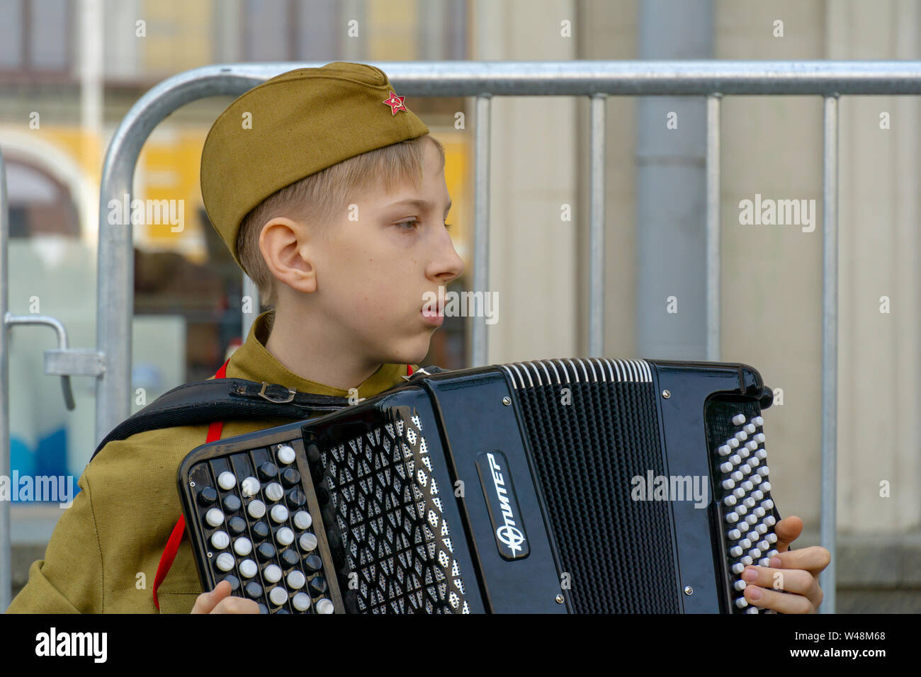 MOSCOW, RUSSIA - MAY 9, 2019: Immortal regiment procession in Victory Day, a soldier kid playing accordion by the artificial camp fire Stock Photo