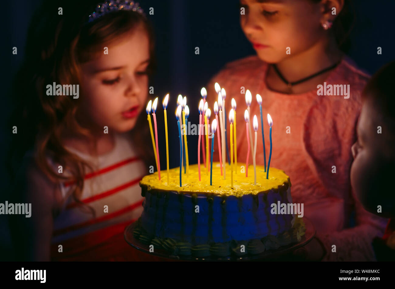 Children's birthday. Children near a birthday cake with candles Stock