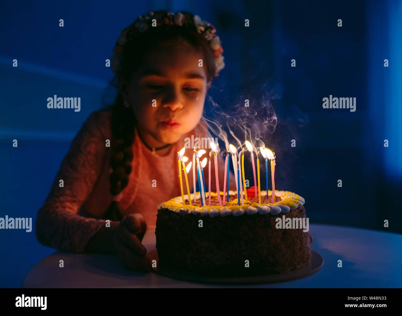 Birthday. A little sweet girl blows out candles on the stoke Stock