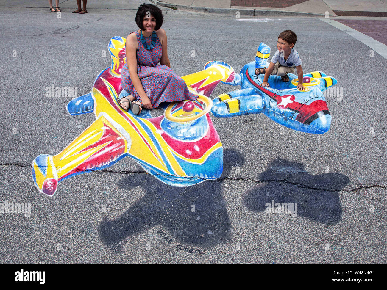 Chicago, USA. 20th July, 2019. People pose for photos with a 3D chalk  drawing of a flying plane during the Chalk Howard Street Festival in  Chicago, the United States, July 20, 2019.