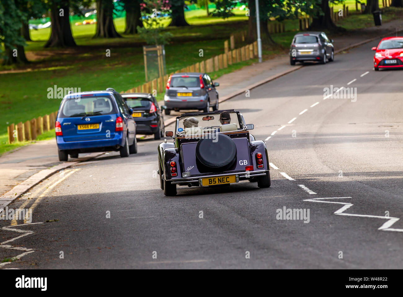 Northampton, UK. 21th July 2019. Weather. A warm sunny morning for this couple out for a drive in their JBA Falcon, open topped sports car along Park Ave South. Credit: Keith J Smith./Alamy Live News Stock Photo
