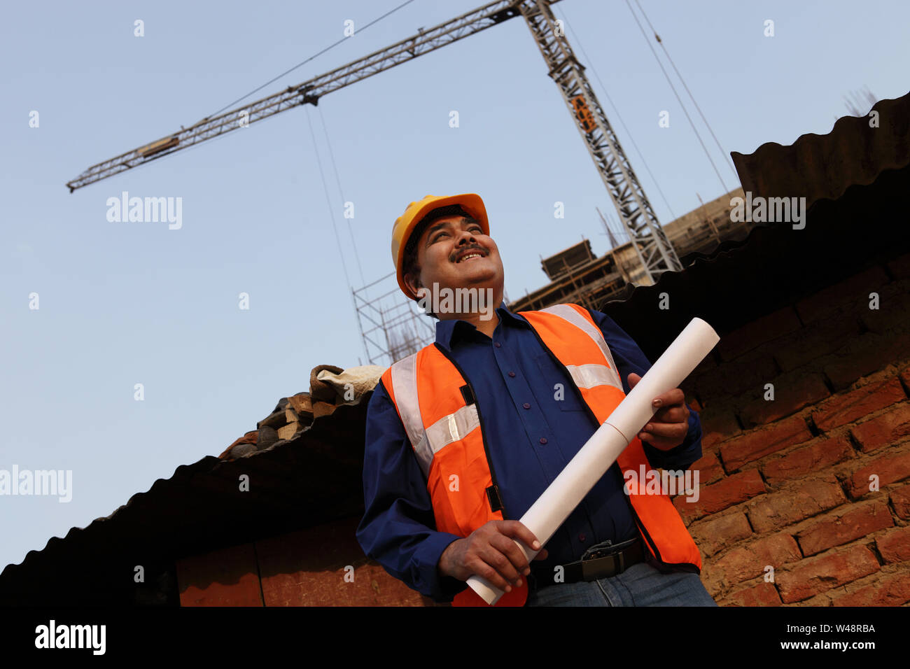 Architect holding blueprint at construction site Stock Photo - Alamy
