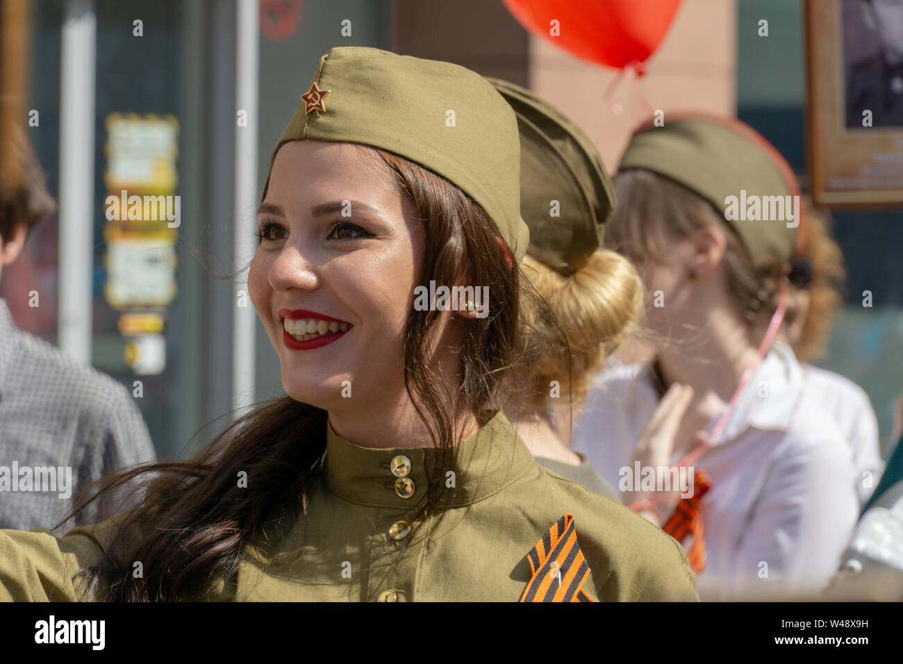 MOSCOW, RUSSIA - MAY 9, 2019: Immortal regiment procession in Victory Day. Thousands of people marching to the Red Square with flags and young girls d Stock Photo
