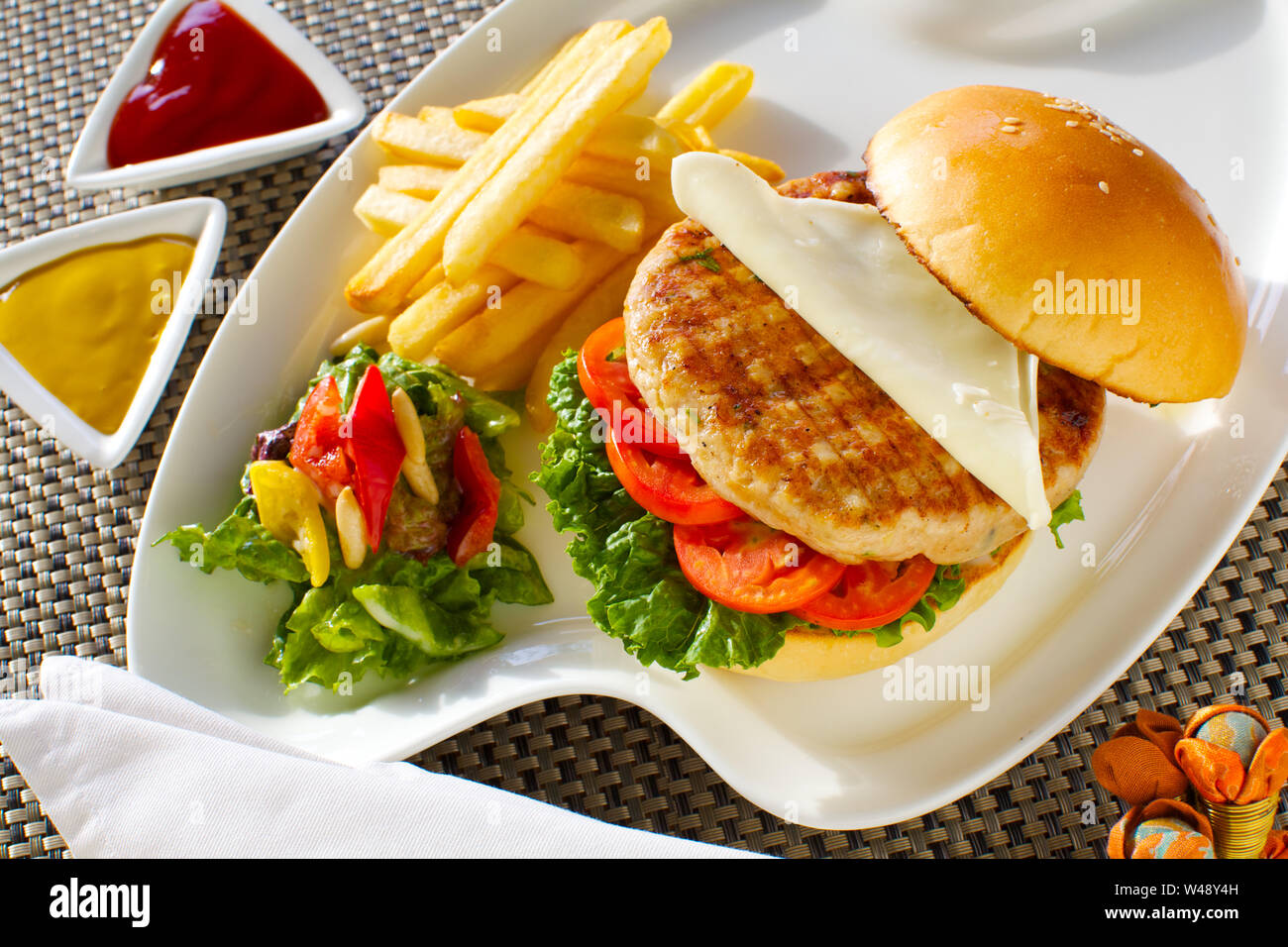 Burger served with french fries and sauces Stock Photo
