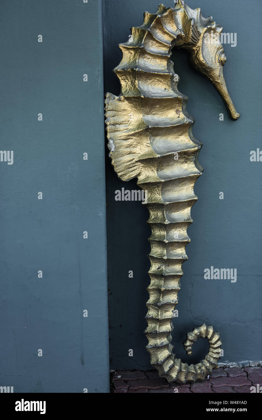 A statue of an endangered seahorse at a local St James cafe leans on a wall in South Africa, near Cape Town Stock Photo