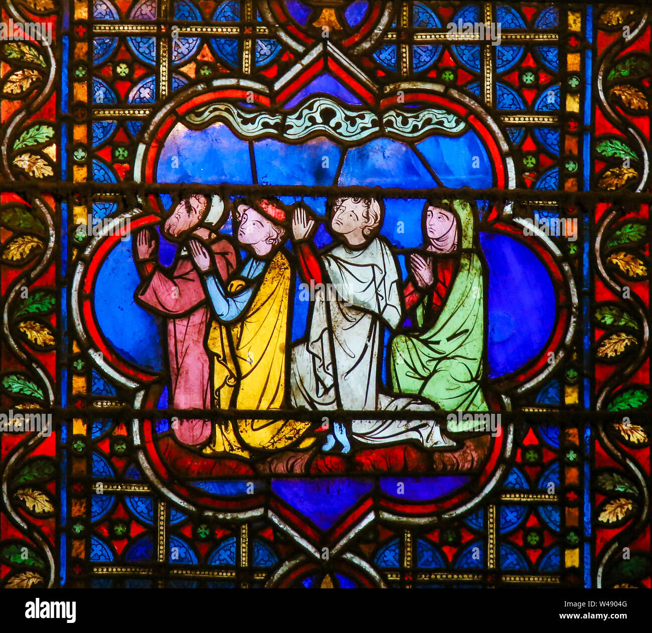 Stained Glass in the Cathedral of Notre Dame, Paris, France, depicting people kneeling and praying Stock Photo