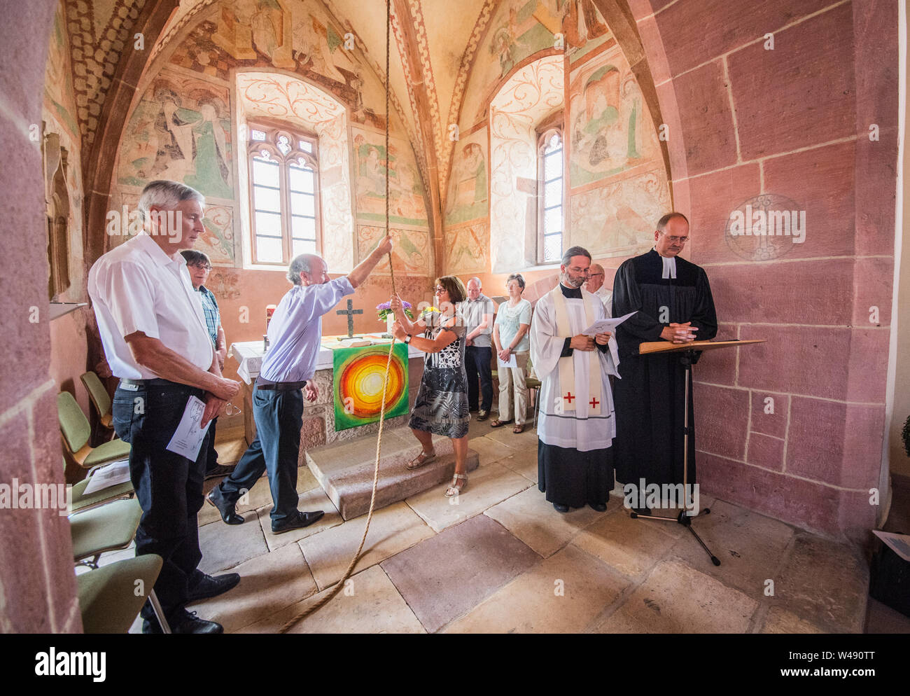 21 July 2019, Rhineland-Palatinate, Essingen: Frank Jordan (M, l-r,),  honorary Protestant church servant of the Wendelinuskapelle, and Roswita  Traub, Gemeindeausschuss katholische Kirchengemeinde Essingen, ring the new  bell in the Wendelinuskapelle ...