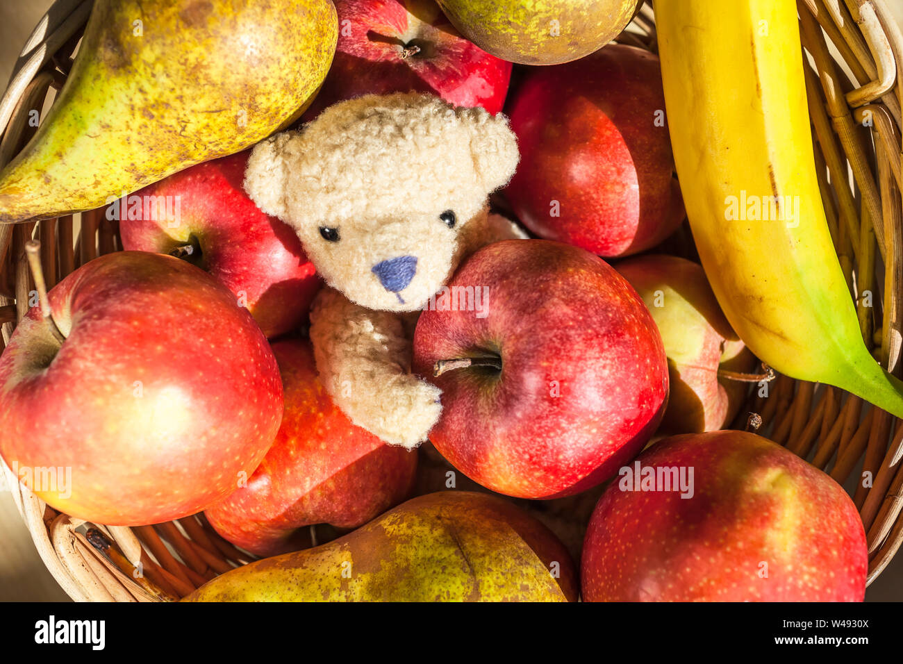 Cute little teddy bear inside fruit basket with apples, pears, banana Stock  Photo - Alamy