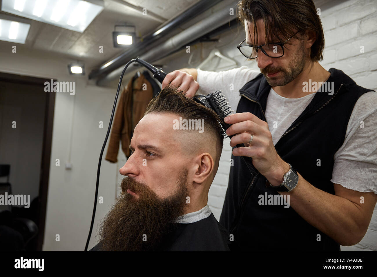 Master Cuts Hair And Beard Of Men In The Barbershop Hairdresser