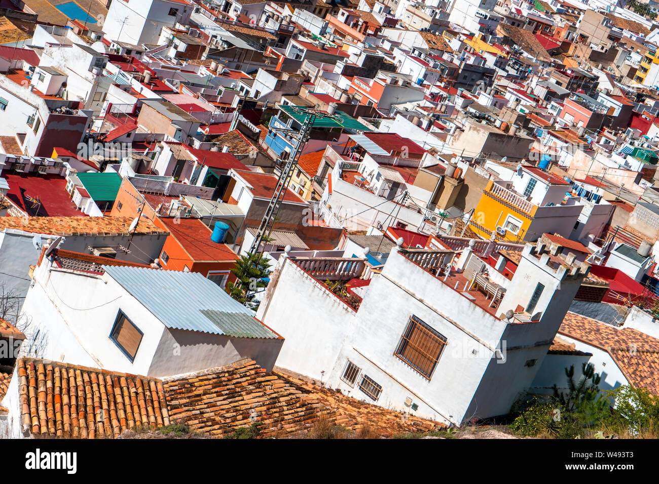 Top view of the bright multi-colored roofs of living houses. Small town - Cullera, Spain, Apr.2019 Stock Photo