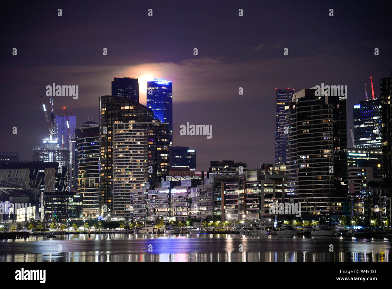 Night Cityscape and Harbour Reflection with Full Moon reflecting onto Victoria Harbour  Docklands Melbourne Victoria Australia Stock Photo