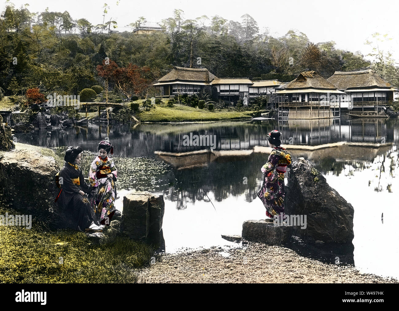[ 1920s Japan - Traditional Japanese Garden ] —   Three maiko admire the view of Genkyu-en Garden (玄宮園) in Hikone (彦根市), Shiga Prefecture, ca. 19251928 (Taisho 14Showa 3).  20th century vintage glass slide. Stock Photo