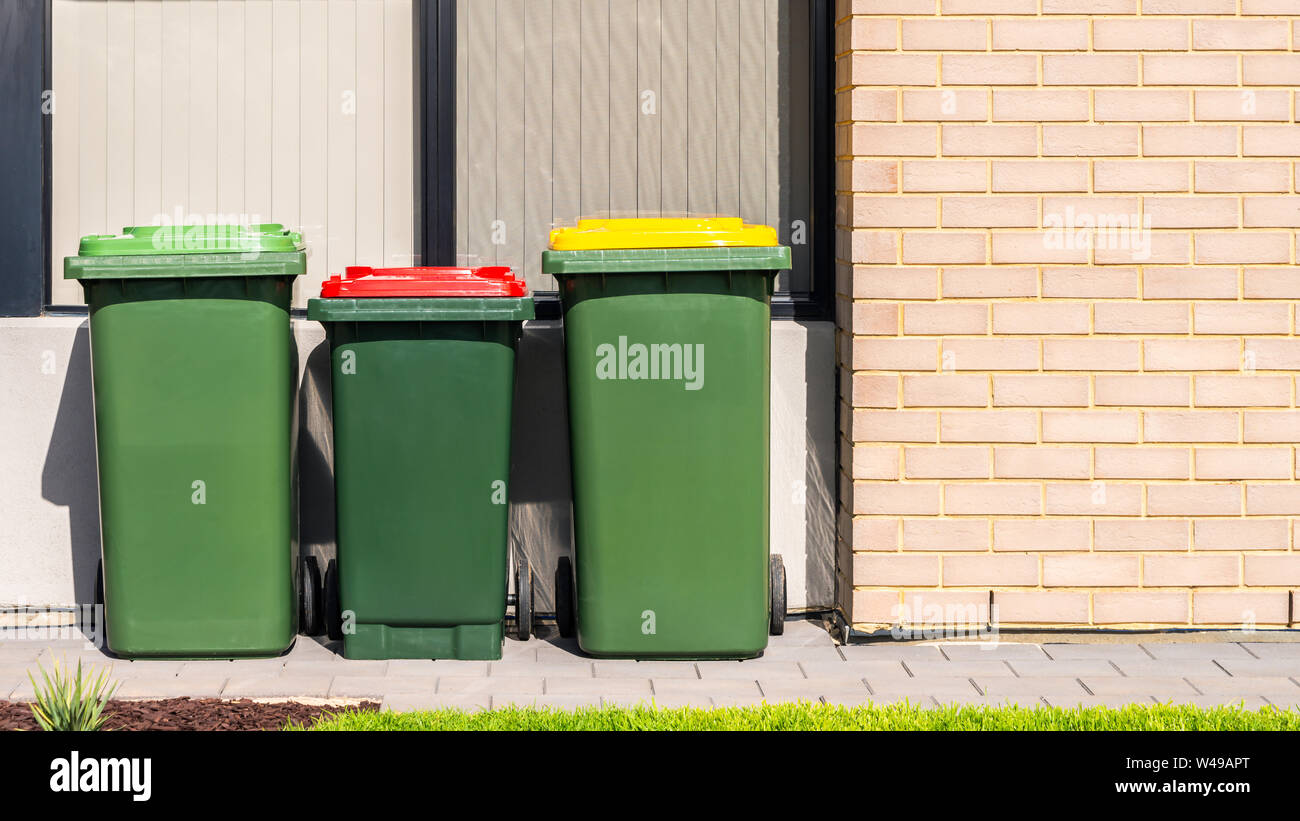 Australian garbage wheelie bins with colourful lids for recycling, general and green waste provided by local council Stock Photo