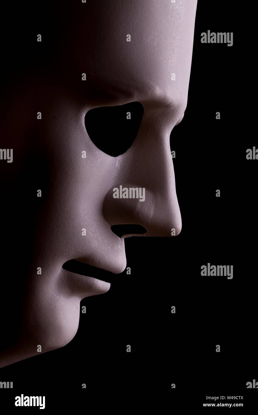 Robot face mask side view close up with textured skin and blank eyes. Black background and space for text. Artificial intelligence concept in a human Stock Photo