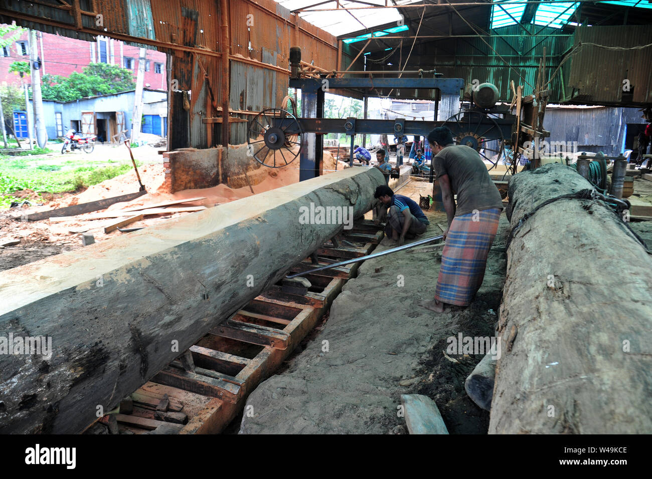 Bangladeshi worker processing wood in a saw mill near Dhaka in
